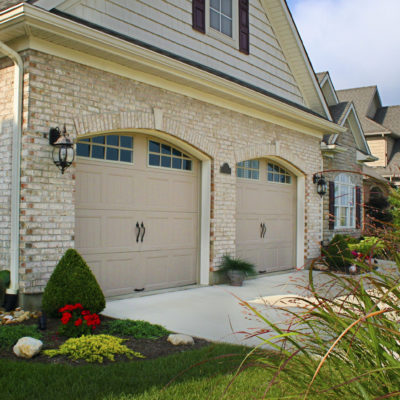 tan arched garage doors with arched windows in steel by clopay