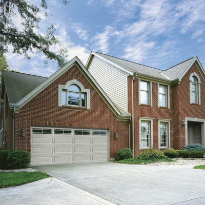 tan paneled garage door with windows and prairie grids by clopay