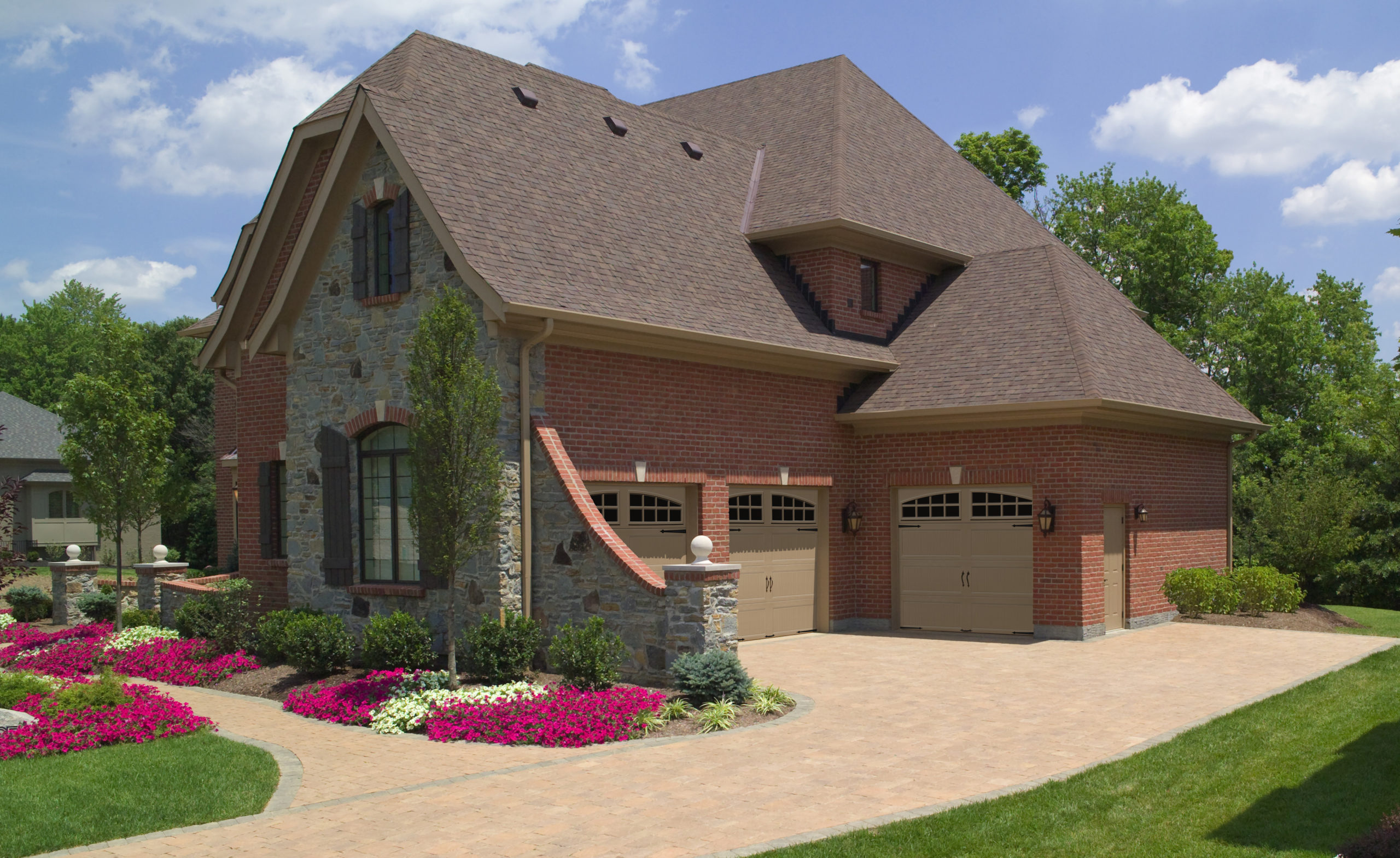 tan steel garage doors with arched windows by clopay