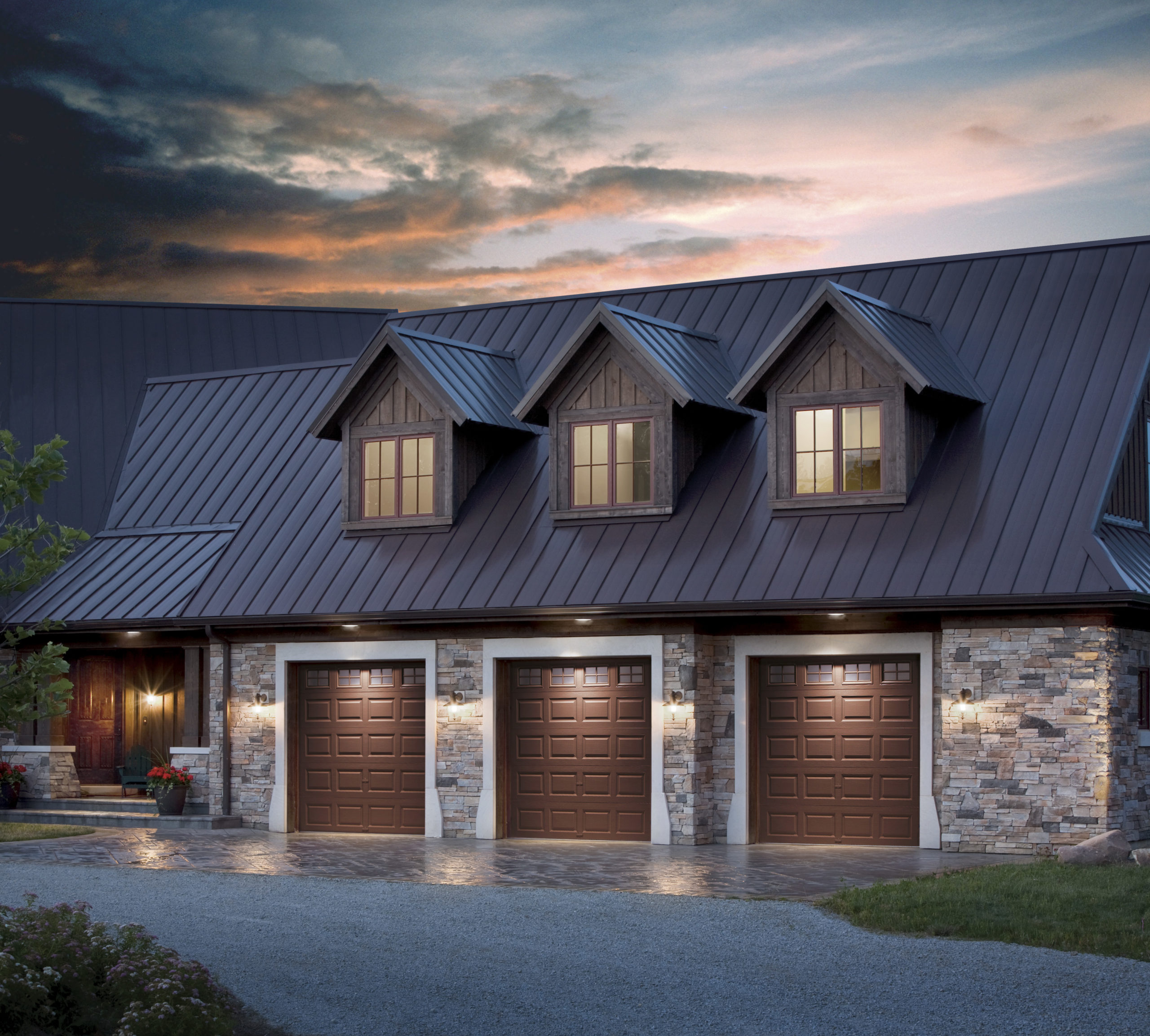 three single car garage doors with wood grain panels and windows by clopay