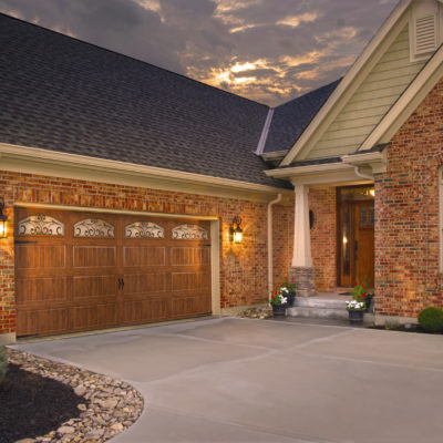 wood grain steel garage door with arched windows and iron by clopay