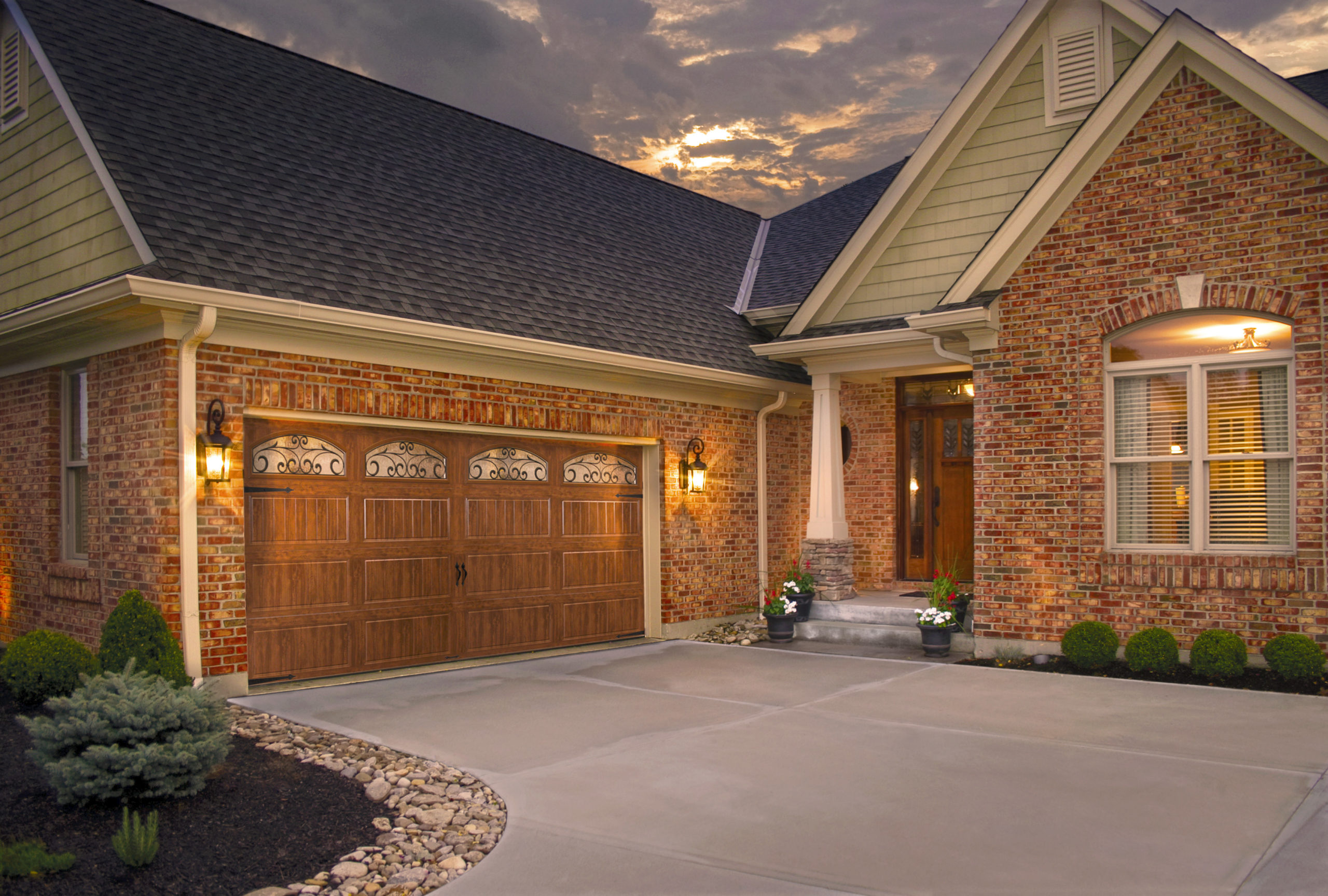 wood grain steel garage door with arched windows and iron by clopay