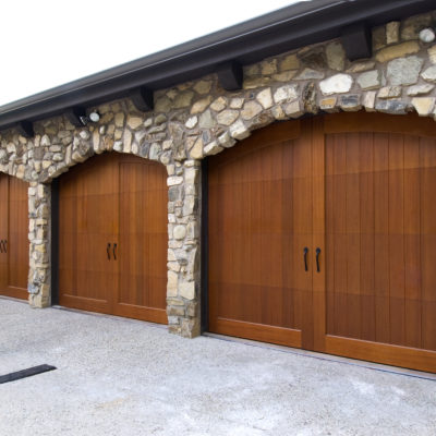 three single car arched top wood garage doors by clopay