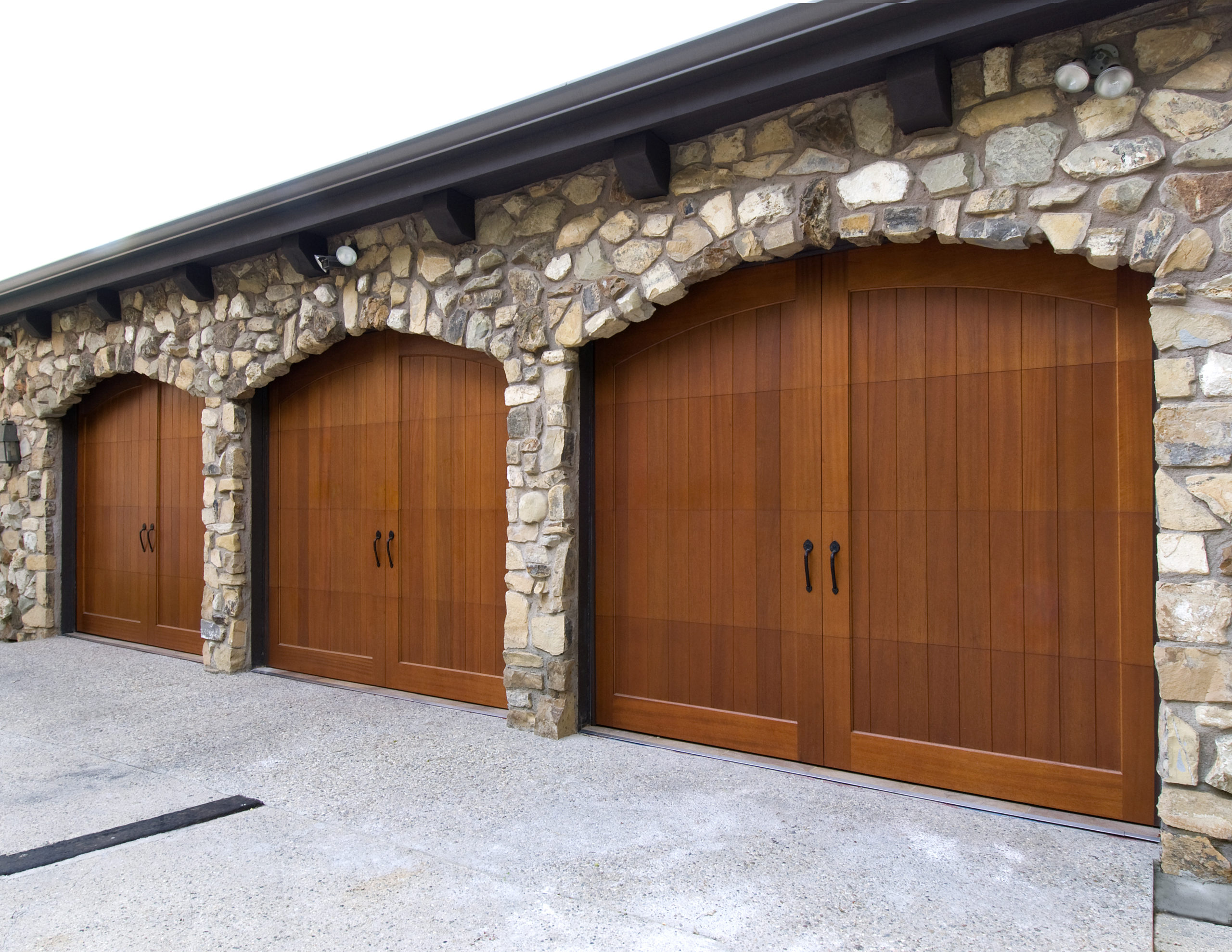three single car arched top wood garage doors by clopay