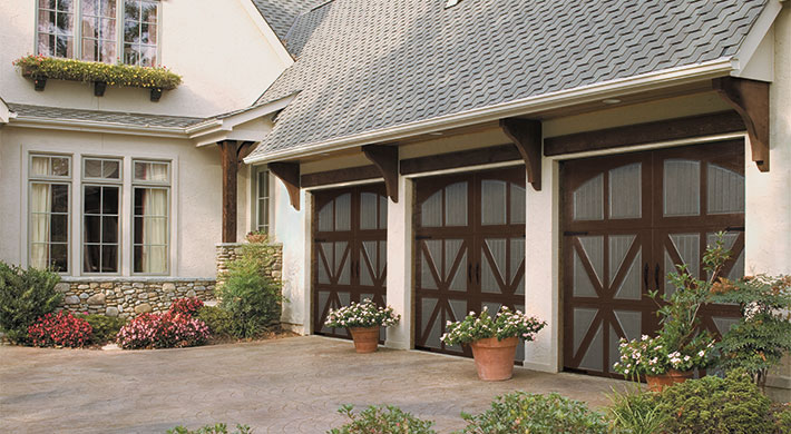 tudor style garage door in wood with arched windows by amarr