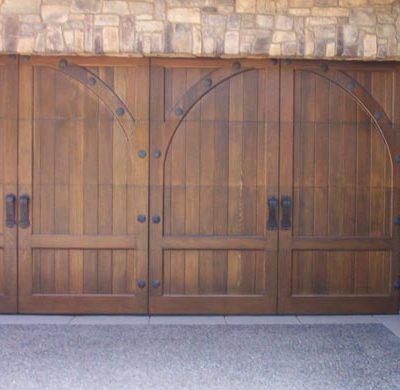 medieval wooden arched garage door with hardware
