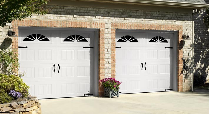 two white one car carriage house garage doors by amarr