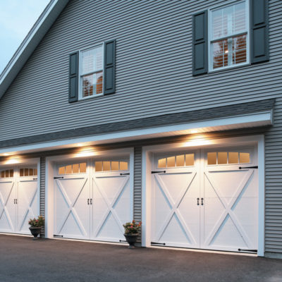 two story house with three white overhead doors courtyard collection garage doors.