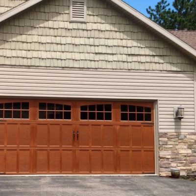 overhead carriage house garage door with a woodgrain texture and stained finish