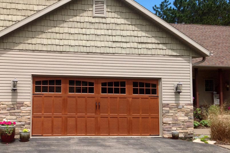 overhead carriage house garage door with a woodgrain texture and stained finish