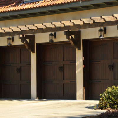 three overhead signature carriage garage doors in a dark wood finish