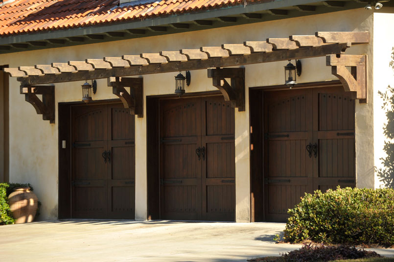 three overhead signature carriage garage doors in a dark wood finish