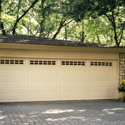 overhead traditional steel garage door with classic design, tan color, and top panel with windows