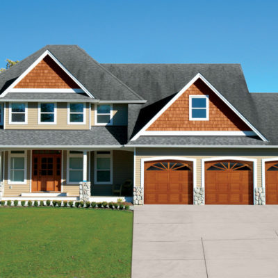 home with three overhead traditional wood garage doors