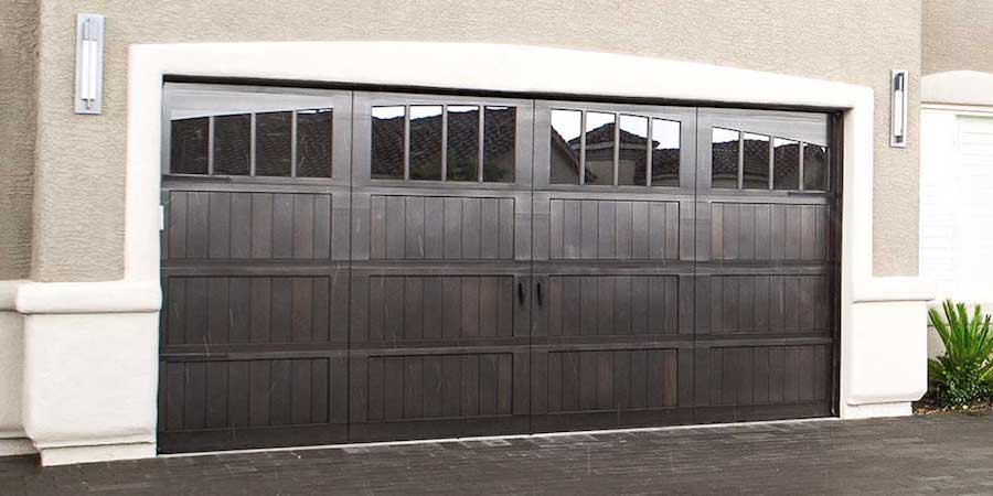 Beautiful dark wood garage door with windows in the top panel.