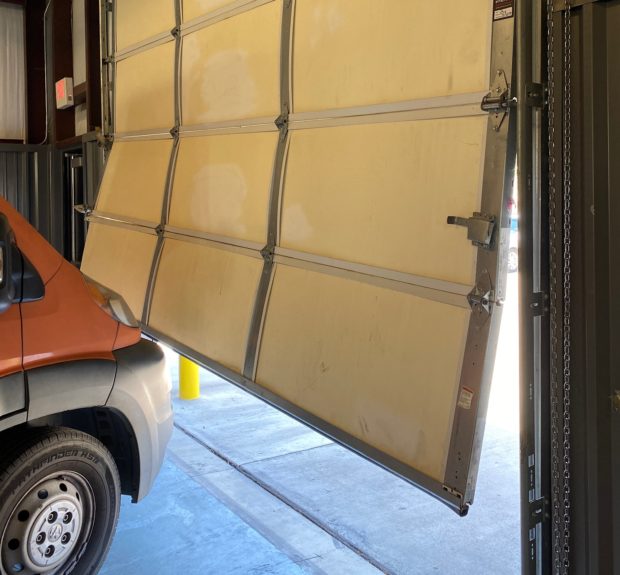 garage door section damaged by car