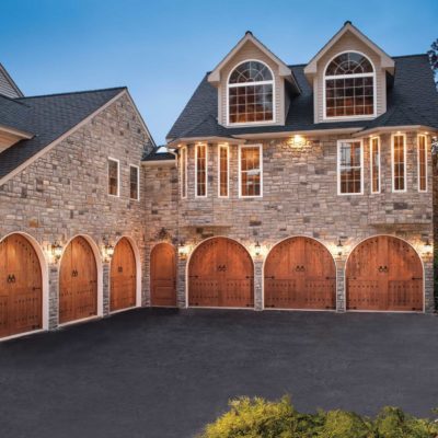 round top carriage house wood garage doors with decorative bronze hardware