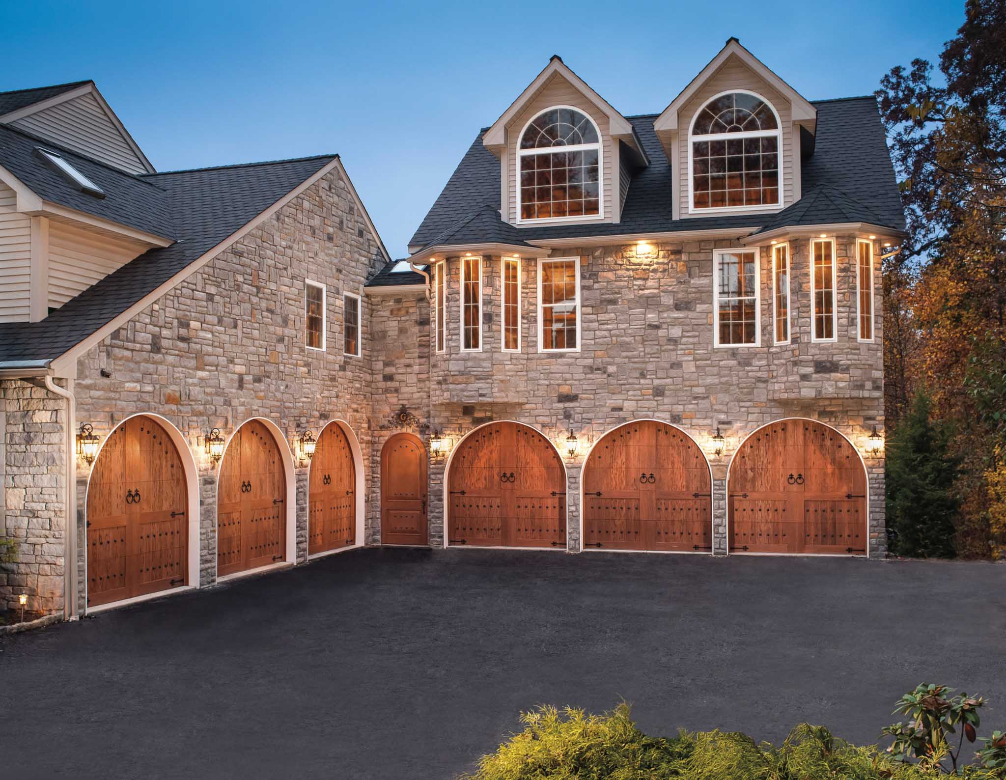 round top carriage house wood garage doors with decorative bronze hardware