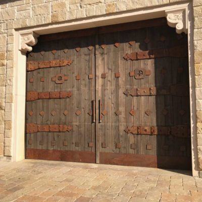 rustic custom wood garage door with rusted hardware