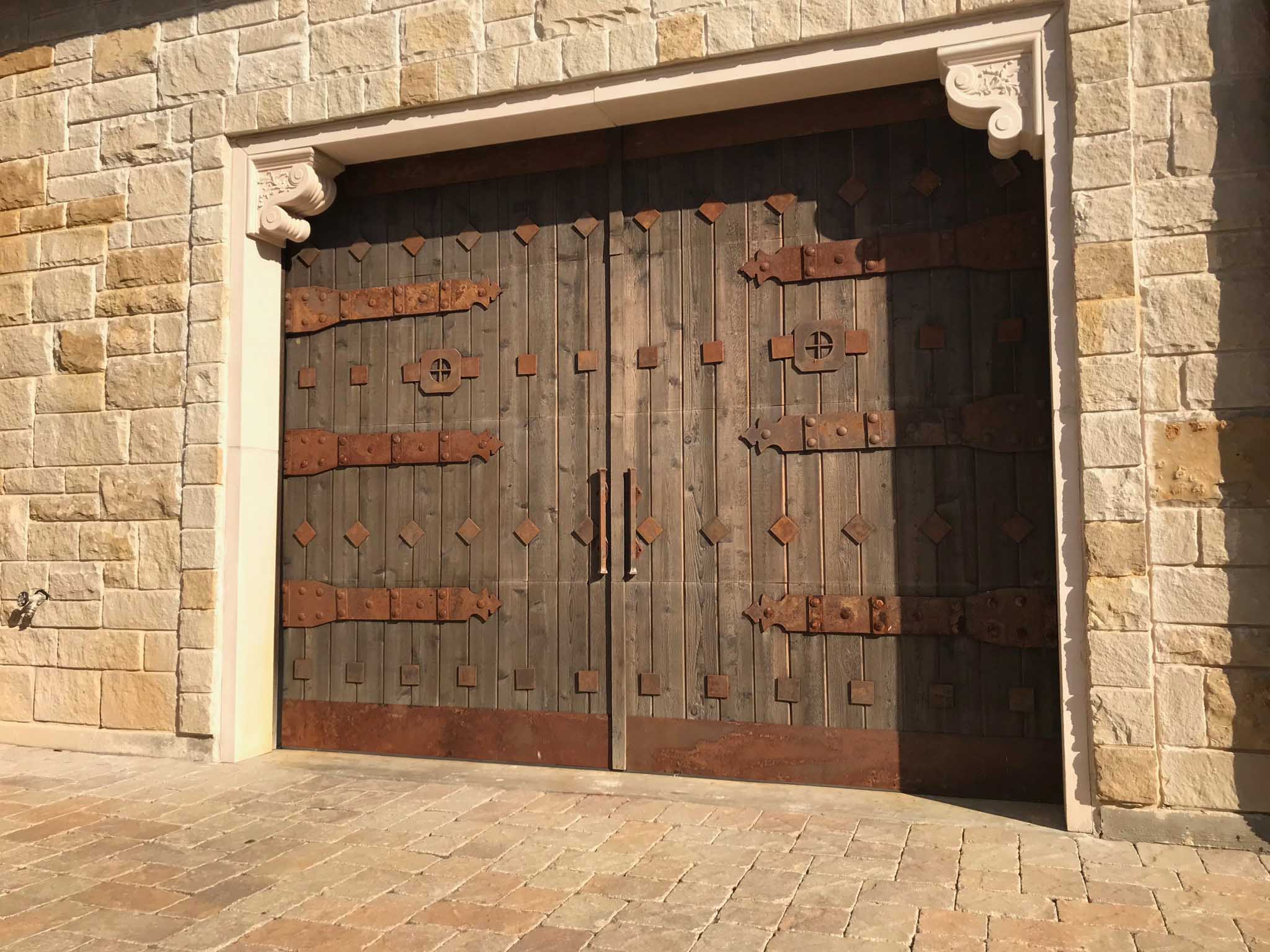 rustic custom wood garage door with rusted hardware