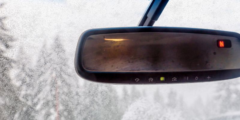 Closeup photo of a rearview mirror with Homelink buttons.