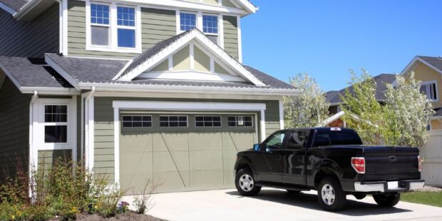 Photo of a house with a black pickup truck on the driveway.