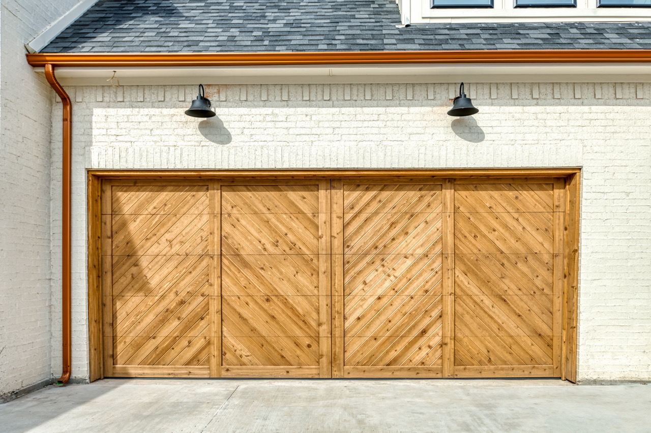 cedar chevron garage door with white brick and copper gutter